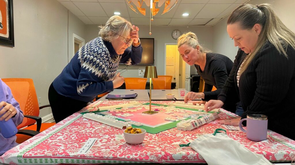 Four ladies studying a mahjong table
